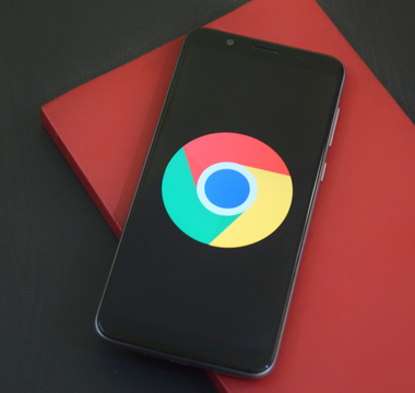 Smartphone på rød baggrund, der symboliserer digital optimering og synlighed gennem Google My Business.